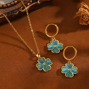 Detaillierte Ansicht des blauen Kleeblatt-Anhängers an einem goldenen Halskettenset.
