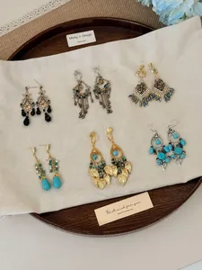 Detailweergave van diverse vintage boheemse kwastjes oorbellen met turquoise en parels.