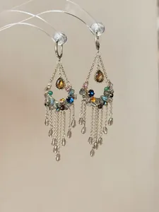 Macrodetail van vintage zilveren kwastjes oorbellen met kleurrijke kristallen hangers