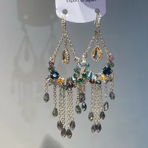 Detail van vintage oorbellen in etnische stijl met kleurrijke kristallen en kwastjes