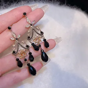 Detail van vintage oorbellen met zwarte kristallen druppels en zilveren naalden.