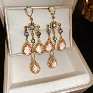 Vintage-style water-drop tassel earrings with pink crystals in a jewelry box