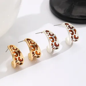 Nahaufnahme von Vintage-Creolen mit Leopardenmuster in elegantem Gold- und Weißton