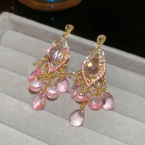 Vintage style pink faceted teardrop crystal tassel earrings on grey velvet display
