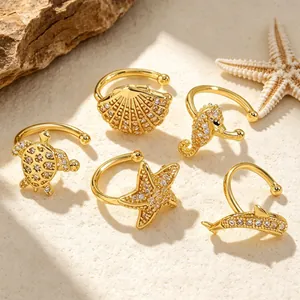 Detail view of gold maritime ear cuffs featuring turtle, starfish and seahorse designs.