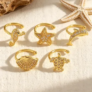 Detailed view of gold ocean-themed ear cuffs with sparkling zircon stone accents