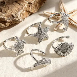 Detail view of sparkling zircon ocean-themed ear cuffs with turtle and starfish