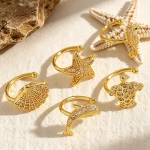 Detailed shot of gold sea-themed ear cuffs featuring turtle, shell, and starfish designs