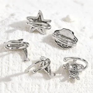 Detailed view of silver ocean-themed ear cuffs featuring starfish, shell and turtle motifs