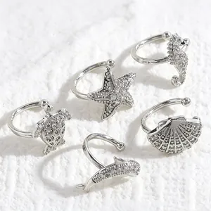 Detailed view of marine themed zircon ear cuffs featuring turtle, starfish and shell shapes