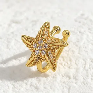 Close-up detail of a gold starfish ear cuff adorned with sparkling cubic zirconia crystals