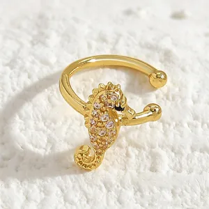 Detailed view of a golden seahorse ear cuff encrusted with sparkling zircon stones