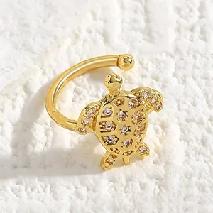 Close-up of a gold sea turtle ear cuff featuring sparkling white zircon embellishments