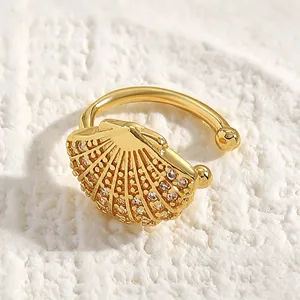 Macro view of an elegant gold shell-shaped ear cuff featuring sparkling zircon stones.