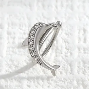 Detailed macro view of a silver dolphin ear cuff encrusted with sparkling zirconia stones.