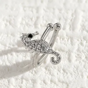 Macro view of a silver seahorse ear cuff encrusted with sparkling clear zircons.