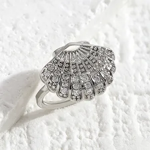 Macro view of a silver shell ear cuff encrusted with sparkling zircon stones.