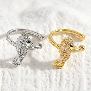 Detail shot of silver and gold seahorse ear cuffs with sparkling zircon stones