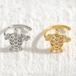 Detailed close-up showing gold and silver sea turtle ear cuffs with sparkling zircons