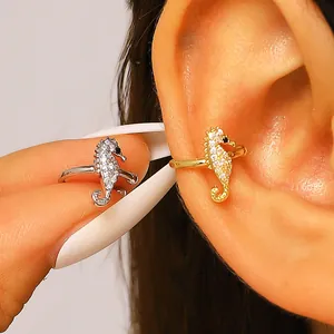 Detail of sparkling zircon seahorse ear cuffs in gold and silver for non-pierced ears