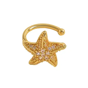 Close-up detail of a gold starfish ear cuff with sparkling zircon inlay for women