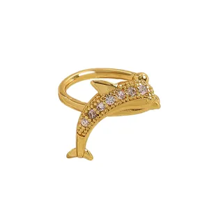 Detailed macro view of gold-tone dolphin ear cuff featuring sparkling white zircon stones