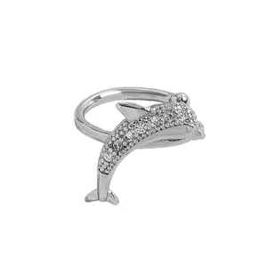 Macro detail of silver dolphin ear cuff jewelry with shimmering clear zircon stones