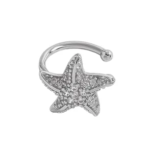 Macro detail of a silver-tone starfish ear cuff pavé-set with sparkling zircons.
