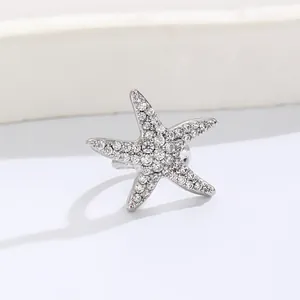 Detail view of silver starfish ear cuff encrusted with sparkling clear zircons