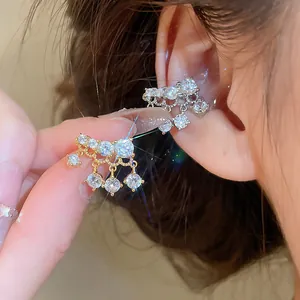 Close-up detail of sparkling cubic zirconia tassel ear cuff with 18k gold plating finish.