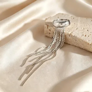 Macro detail shot of a silver stainless steel tassel ear cuff on a silk background