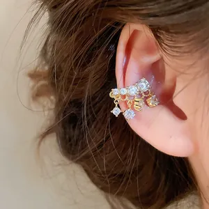 Macro shot of a luxury gold-plated ear cuff featuring sparkling cubic zirconia tassels