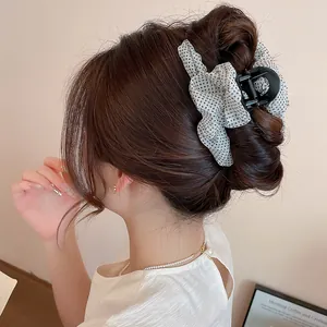 Primer plano de una pinza para el pelo a lunares plisada usada en un moño.