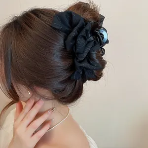 Primer plano de una pinza para el pelo de tela negra rizada en un moño muy elegante