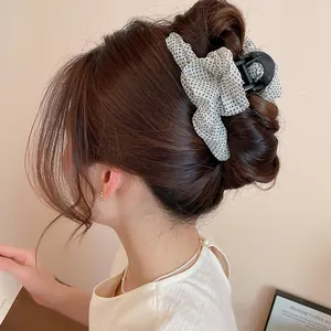 Detalle de una pinza para el pelo vintage con lunares y malla en un moño elegante