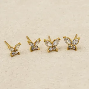 Close-up of four gold-plated butterfly stud earrings with sparkling cubic zirconia stones