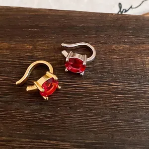 Μινιμαλιστικό επιχρυσωμένο ear cuff με ζωντανές κόκκινες οβάλ πέτρες ζιργκόν σε ξύλο
