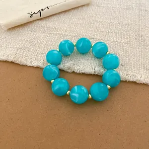 Close-up detail of vibrant turquoise acrylic beads on a summer dopamine style bracelet