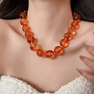 Amber chunky acrylic bead necklace worn on neck, vibrant summer dopamine style.