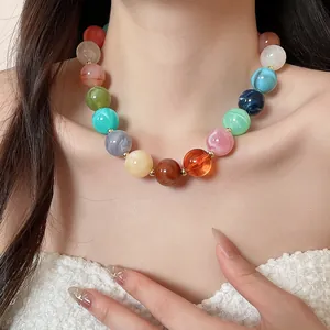 Close-up detail of a colorful round acrylic beaded necklace in vibrant dopamine style