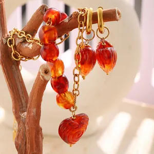 Detailed view of vintage amber heart necklace and earrings on a rustic branch