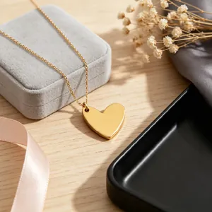 Detailed view of a minimalist gold stainless steel heart pendant necklace on box