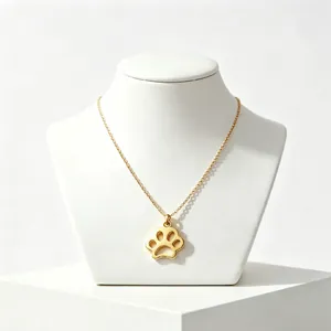 Detailed view of a gold-plated stainless steel paw print pendant necklace on a display bust.