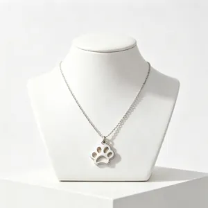 Detailed macro shot of a minimalist silver stainless steel pet paw print pendant necklace