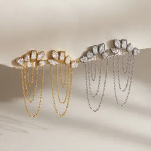 Detailed macro view of gold and silver zirconia tassel earrings with elegant chains