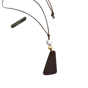Kette mit braunem Harz-Anhänger im Vintage-Stil, Ethno-Kordel und graviertem Metallanhänger