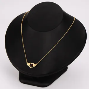 Detail of angel wing heart necklace with projection stone in gold stainless steel finish