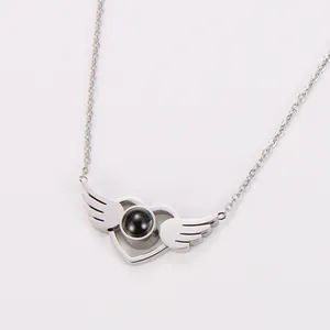 Detailed view of angel wing heart pendant with central projection stone in silver finish