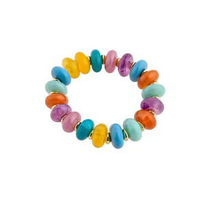 Bracelet en perles acryliques multicolores vibrantes avec entretoises dorées sur fond blanc.