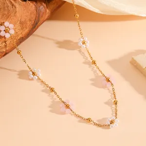Detailed macro shot of stainless steel necklace with pink and white floral beads.